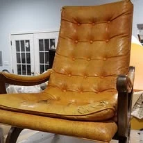 Before: light-brown tufted leather chair with visible wear